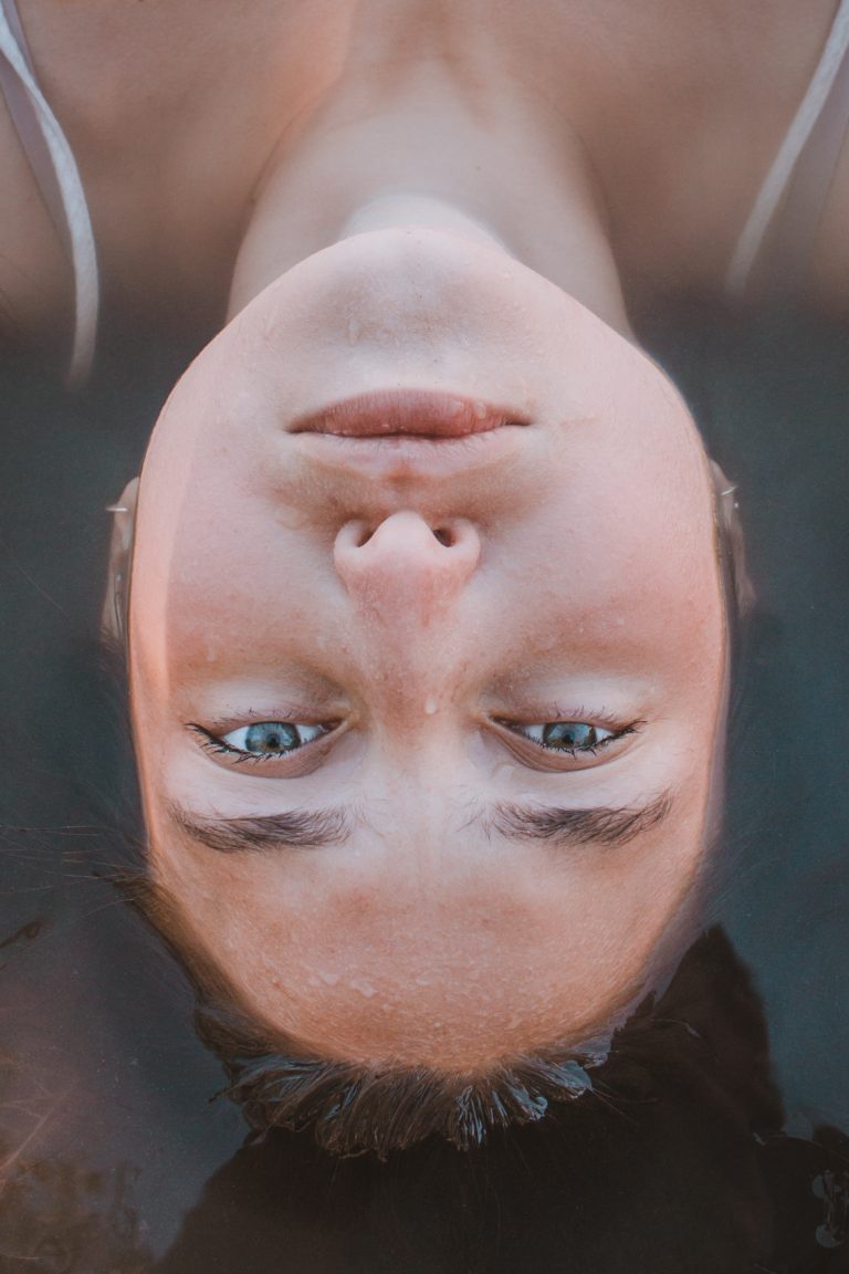 woman lying on body of water in closeup photography