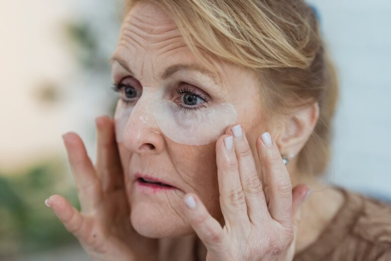 older woman using under eye mask